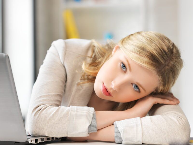 Concerned-Woman-Laptop-Featured Blonde woman in pain with head on folded arms in front of laptop
